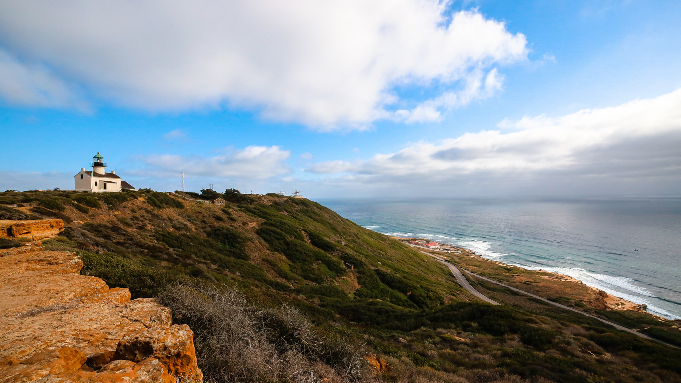 Old Point Loma lighthouse tiny on oceanside cliff; Courtesy U.S. National Parks